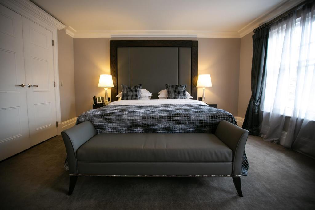 um quarto com uma cama com um sofá e 2 candeeiros em One Warwick Park Hotel em Royal Tunbridge Wells