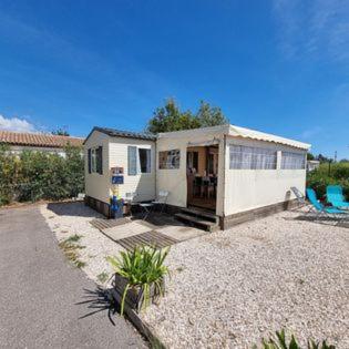 a tiny house is sitting in a gravel yard at MOBILE HOME COSY 4/5 personnes in Hyères