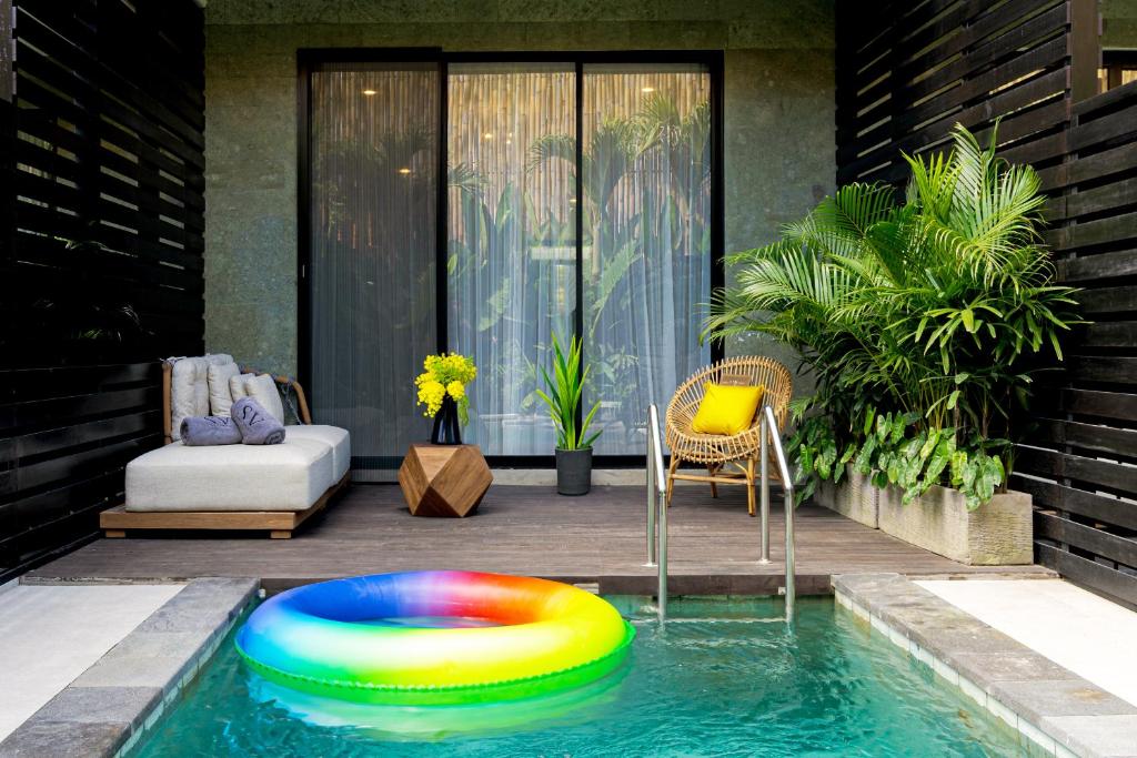 une piscine avec un frisbee coloré dans l'eau dans l'établissement Sunny Village Batu Bolong, à Canggu