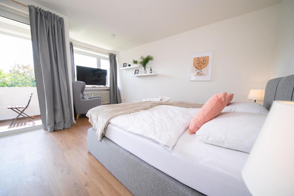 a white bedroom with a bed and a large window at Apartment - Central with kitchen - Balcony - Fair in Neuss