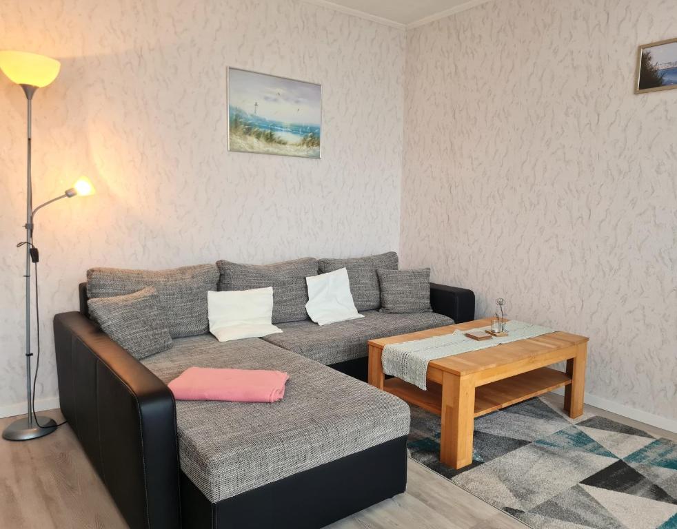 ein Wohnzimmer mit einem Sofa und einem Tisch in der Unterkunft Haus Baltic - App 58 - direkt hinter dem Deich! in Grömitz