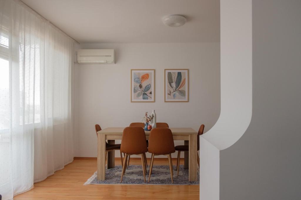uma sala de jantar com mesa e cadeiras em Апартамент за гости Бажолета - светъл и уютен дом в сърцето на Ямбол em Yambol