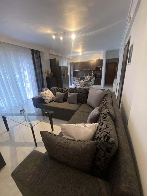 ein Wohnzimmer mit einem Sofa und einem Glastisch in der Unterkunft Comfortable Apartment With Parking in Thessaloniki