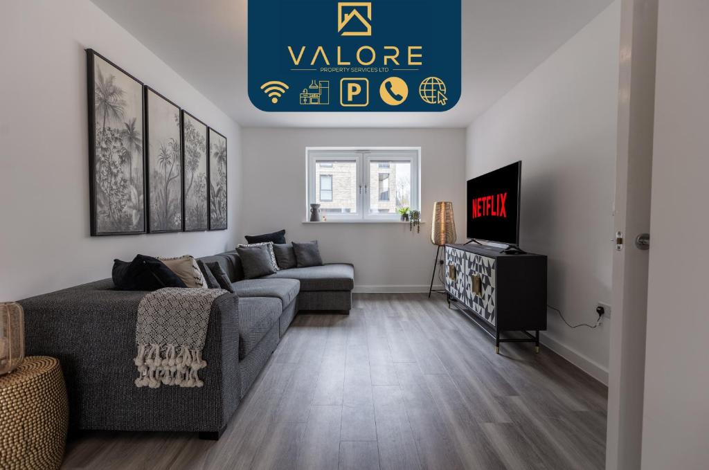 ein Wohnzimmer mit einem Sofa und einem TV in der Unterkunft Outstanding 5 Bedroom Townhouse, Canal Views By Valore Property Services in Milton Keynes