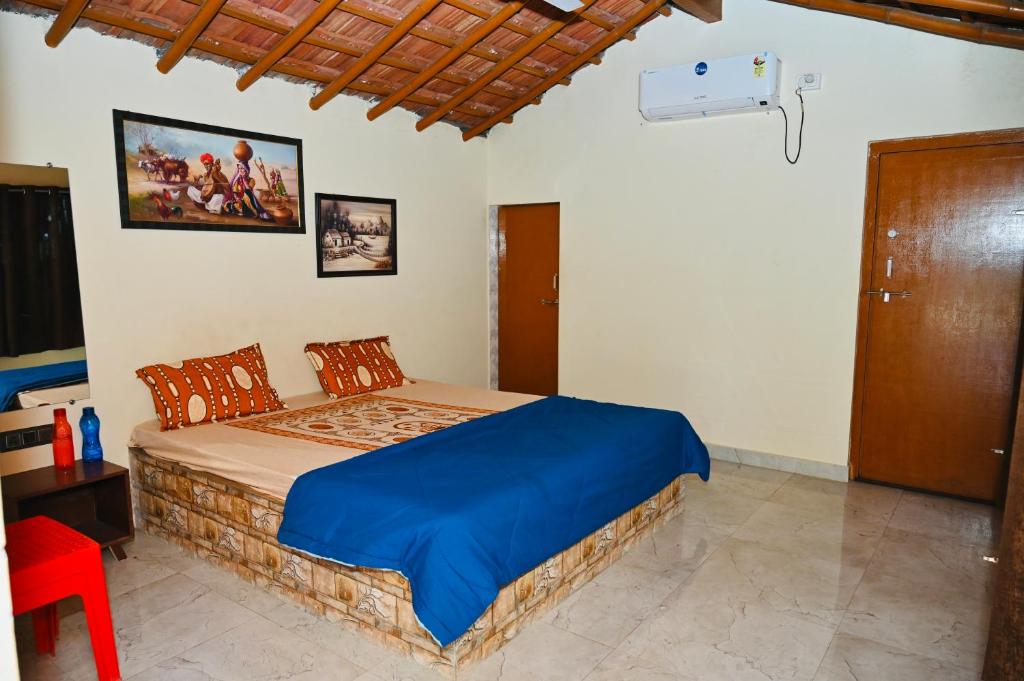 een slaapkamer met een bed en een rode stoel bij Dwarkesh Farm&Resort in Somnath