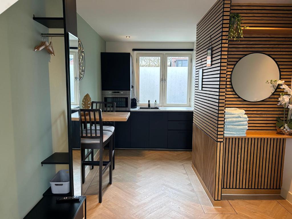 a small kitchen with a table and a mirror at Bnb de leeuw in Badhoevedorp