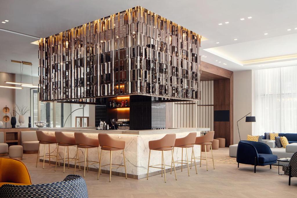 a hotel lobby with a bar and a large chandelier at Courtyard by Marriott Yerevan in Yerevan