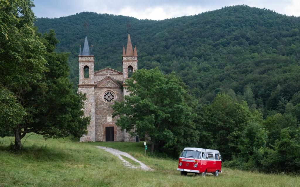 a red van parked in front of an old church at Retro VW Kombi T2 Campervan in Hospitalet de Llobregat
