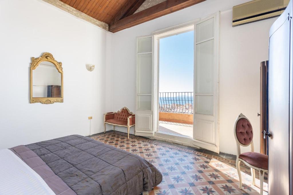 um quarto com uma cama e uma grande janela em La dolce vita em Cagliari
