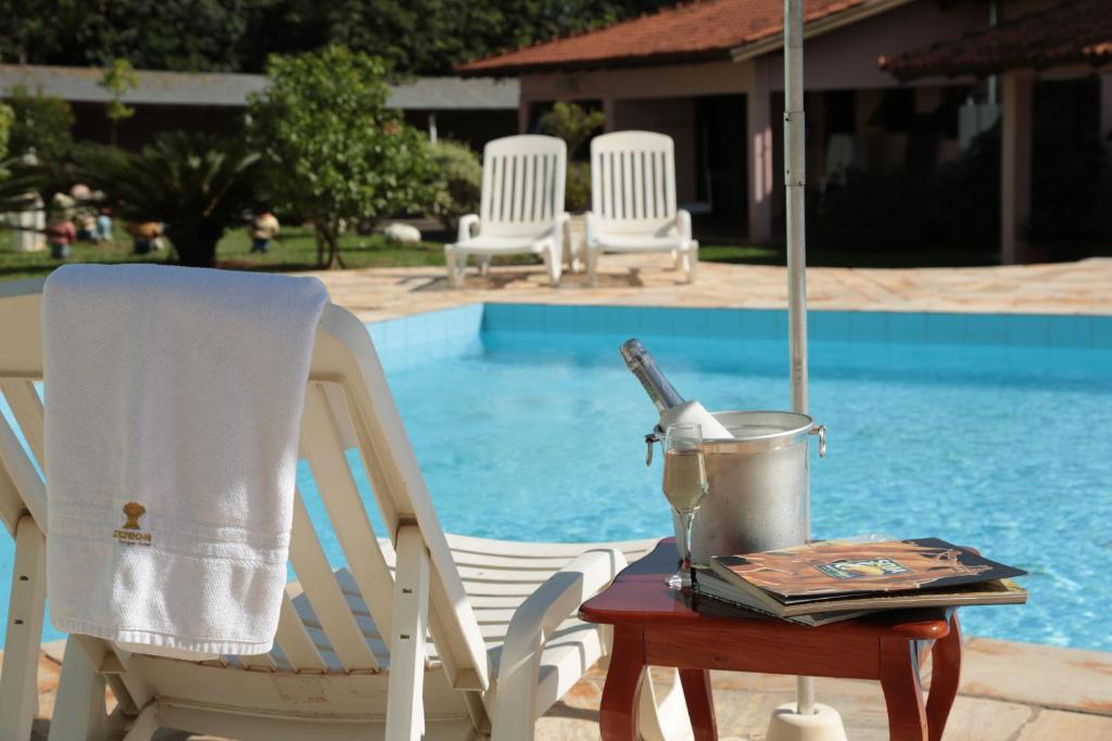a table with a blender and a chair next to a pool at Senior Parque Hotel in Santa Rosa