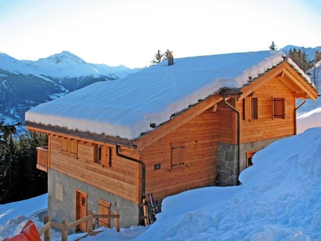 Cabaña de madera con nieve en el techo en Chalet Bryher en Les Collons