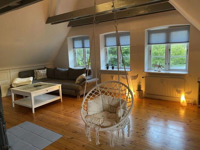 a living room with a couch and a swing at Holiday apartment Möwennest in Lindholm