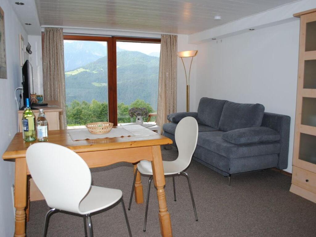 a living room with a table and chairs and a couch at Holiday apartment on the slope in Berchtesgaden