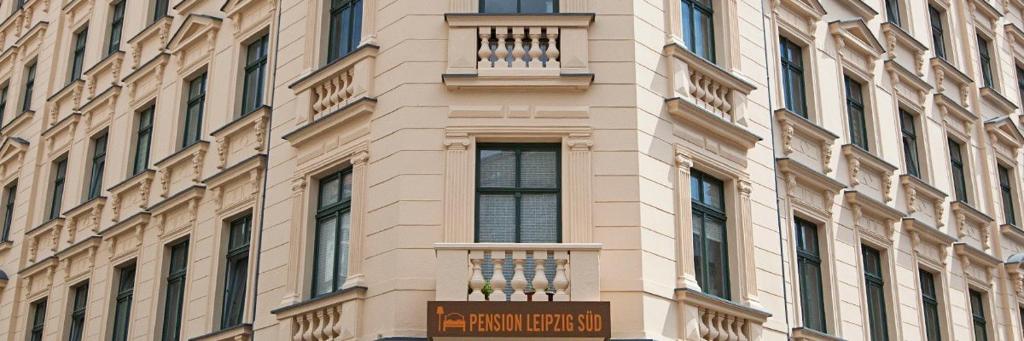 a tall building with a sign in front of it at Pension-Leipzig-Süd in Leipzig