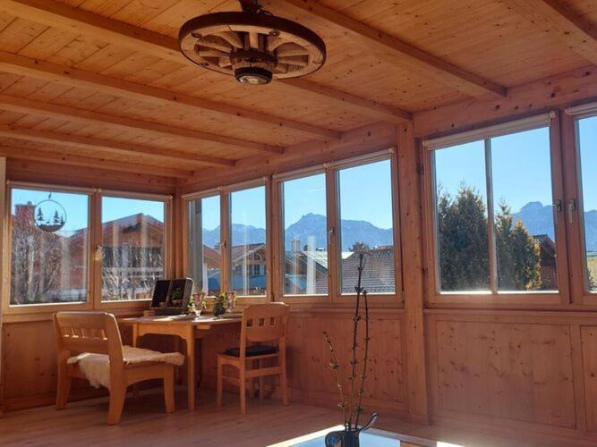a room with a desk with a laptop and chairs at Holiday apartment Edelweiss in Rieden am Forggensee