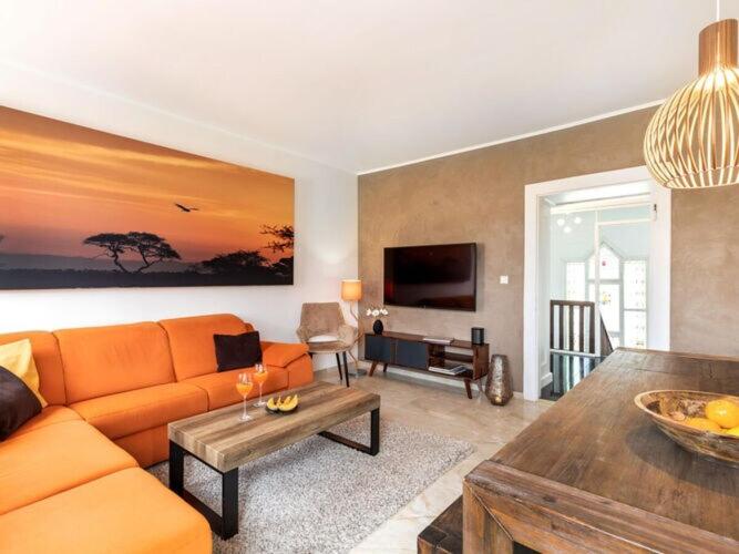 a living room with an orange couch and a table at Holiday apartment Villa PRIMERA in Singen