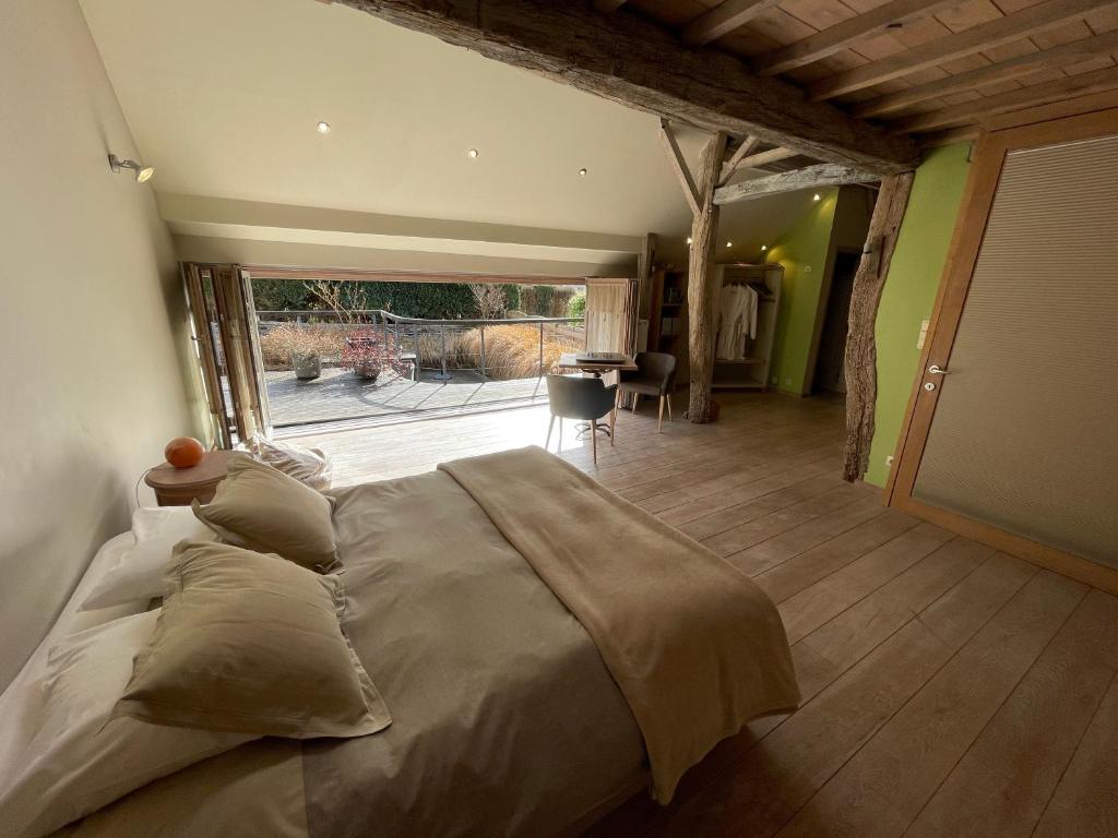 un grande letto in una stanza con una grande finestra di Le Temps d'une Pause a Ny