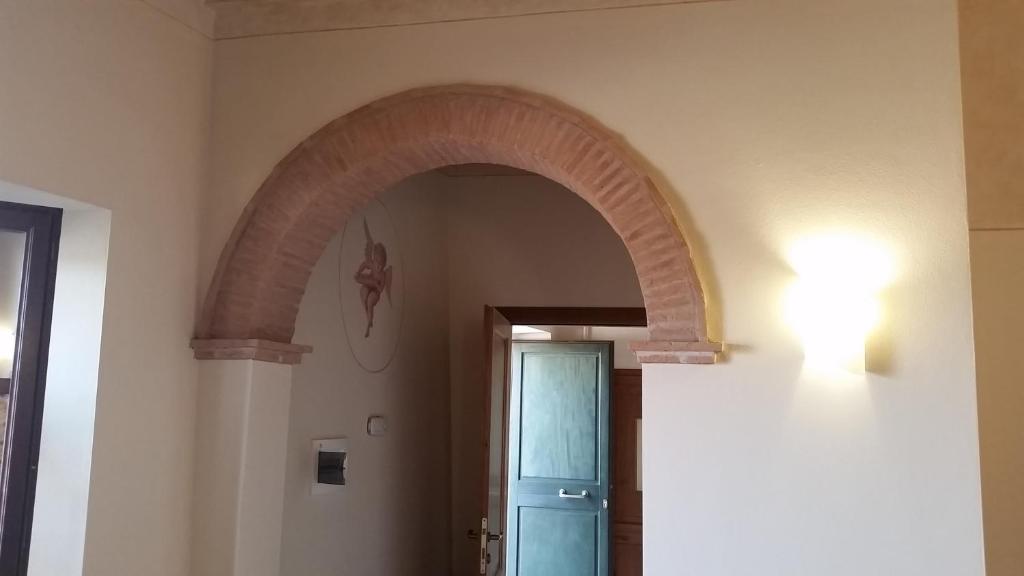 an archway in a hallway with a blue door at Una Finestra sul Silenzio in Santa Luce