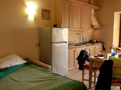 a kitchen with a white refrigerator and a table at Una Finestra sul Silenzio Monolocale in Santa Luce