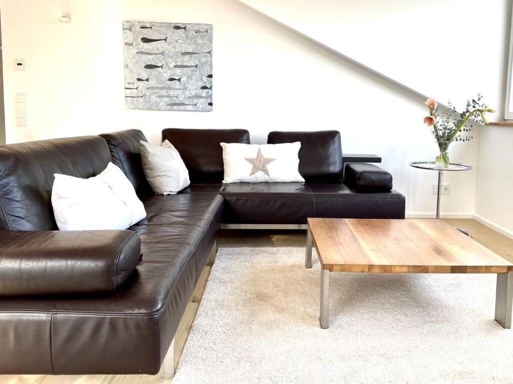 un sofá de cuero negro en una sala de estar con mesa de centro en Holiday apartment Seeloft, en Constanza