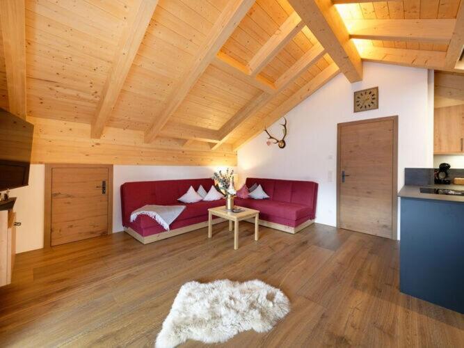 a living room with a red couch and a table at Holiday apartment d'griabige in Farchant