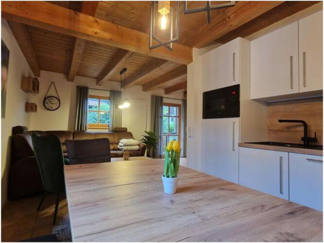 a kitchen with a table with a vase of flowers on it at Susanne - forest holiday village 