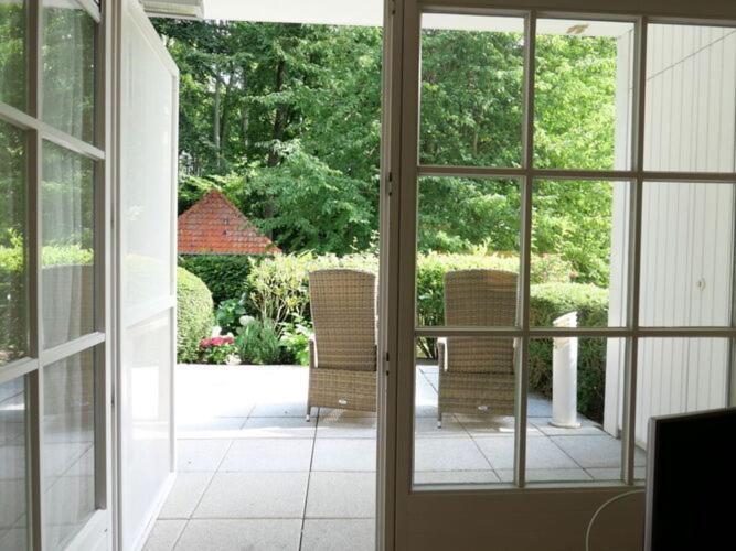 an open door to a patio with two wicker chairs at Holiday vacation by the sea in Travemünde