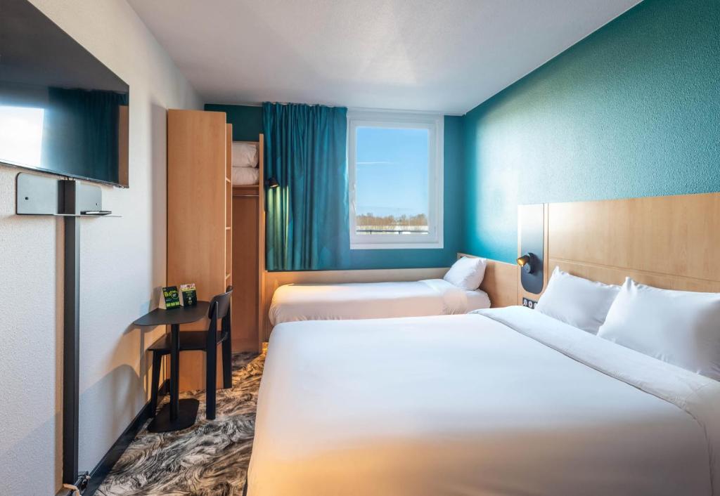 Postel nebo postele na pokoji v ubytování B&B HOTEL Calais Terminal Cité Europe 3 étoiles