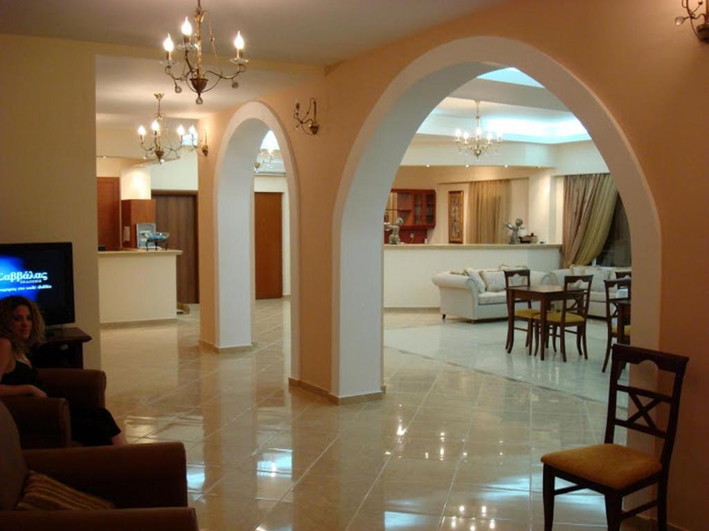 a living room with an archway and a dining room at Nefeli Hotel in Agios Kirykos