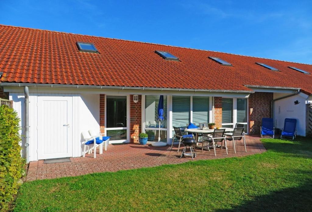 a house with a patio with a table and chairs at Ferienhaus Wohler 9103 - Fehmarn in Fehmarn
