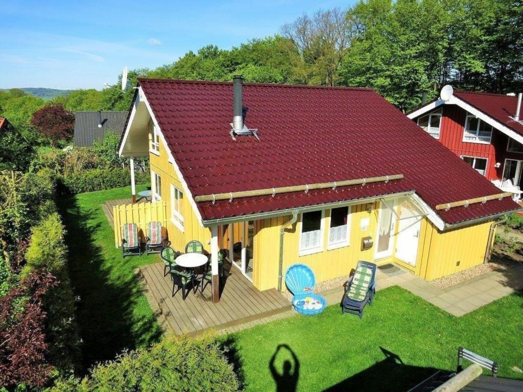 uma vista superior de uma casa amarela com um deque em Gemütliches Ferienhaus Lea für 5 Personen mit Sauna und Kaminofen von Privat im Ferienpark Extertal em Extertal