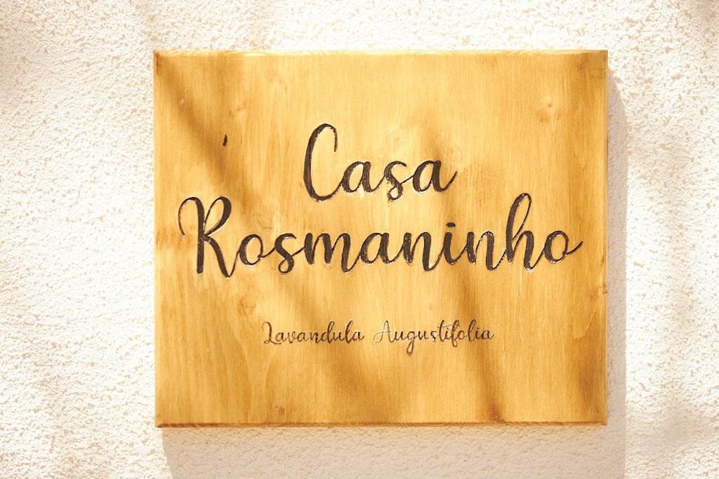 un cartel en una pared con el nombre de un restaurante en Quinta Do Marmeleiro- Casa Rosmaninho, en Santiago do Cacém