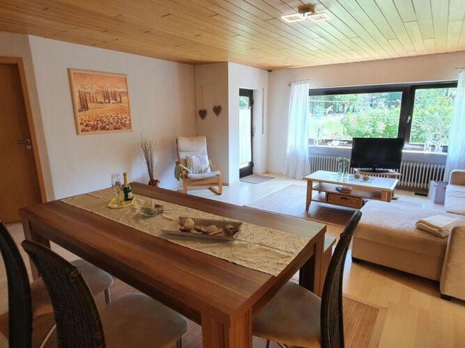 uma sala de estar com uma mesa de jantar e um sofá em Holiday apartment in the garden em Eppenbrunn