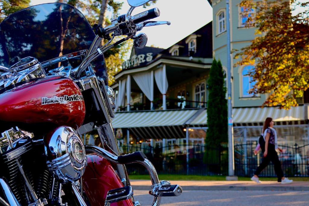 a red motorcycle parked in front of a building at Pegasa Pils Spa Hotel in Jūrmala