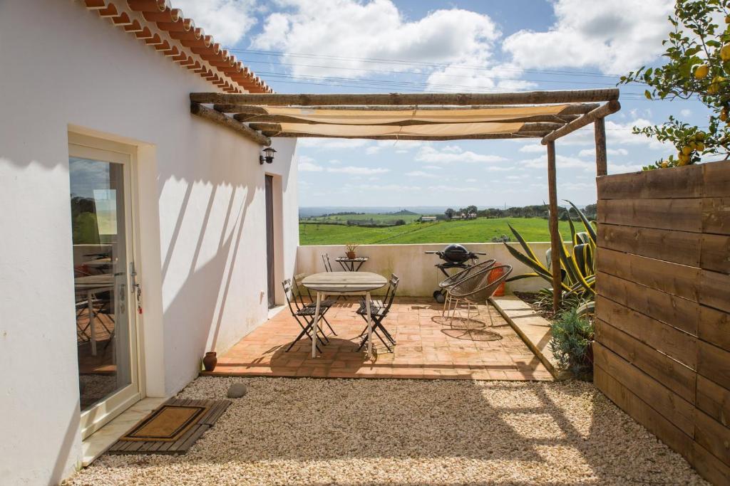 a patio with a table and chairs on a patio at Costa Vicentina cottage with a view in Cercal