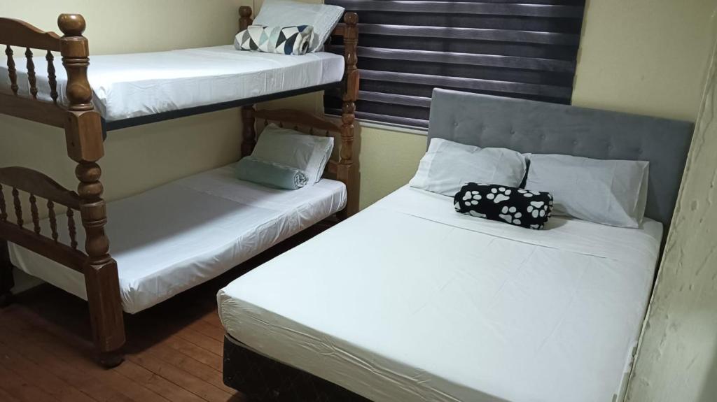 2 Etagenbetten in einem kleinen Zimmer mit in der Unterkunft Habitación privada bombero garrido in Curicó