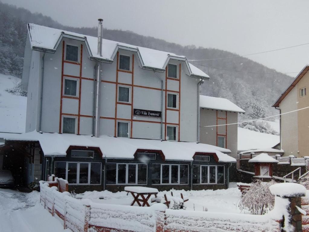 a large building with snow on the ground at Vila Ivanović in Kopaonik