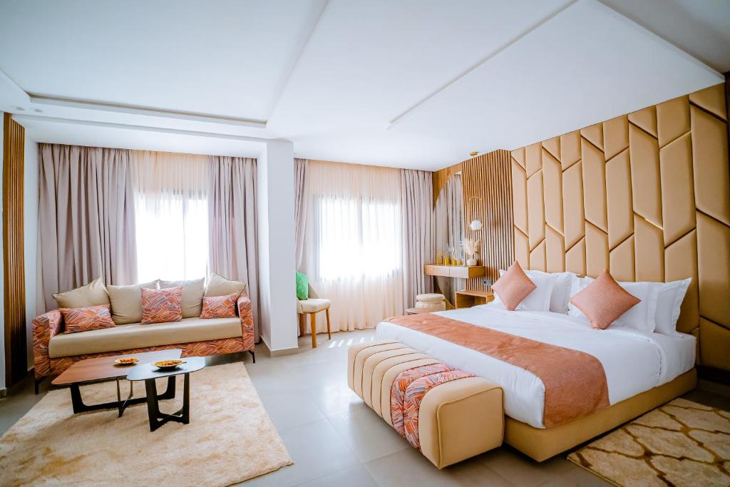 um quarto de hotel com uma cama grande e um sofá em TIMAZIN HOTEL DAKHLA em Dakhla