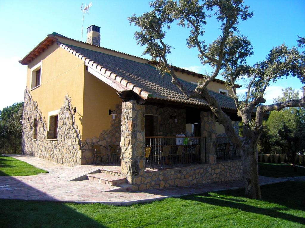 uma casa de pedra com uma árvore em frente em Villa rural en urbanización próxima a Ávila by Alterhome em Peñalba de Ávila