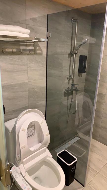 a bathroom with a white toilet and a shower at Dafong Hotel in Zhongzheng