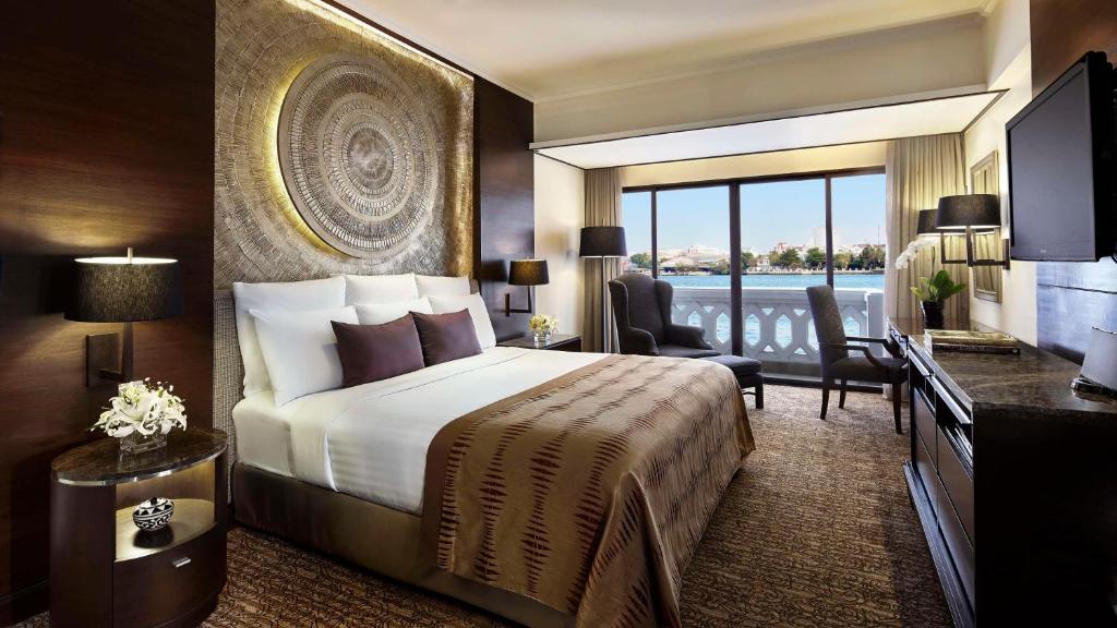 a hotel room with a bed and a large window at Anantara Riverside Bangkok Resort in Bangkok