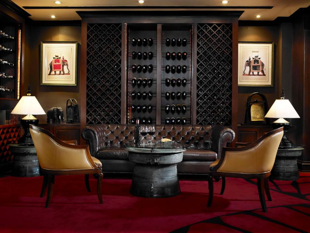 a wine tasting room with a couch and chairs at Anantara Riverside Bangkok Resort in Bangkok