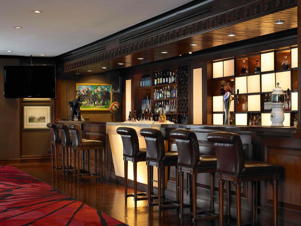 a bar with brown stools in a restaurant at Anantara Riverside Bangkok Resort in Bangkok