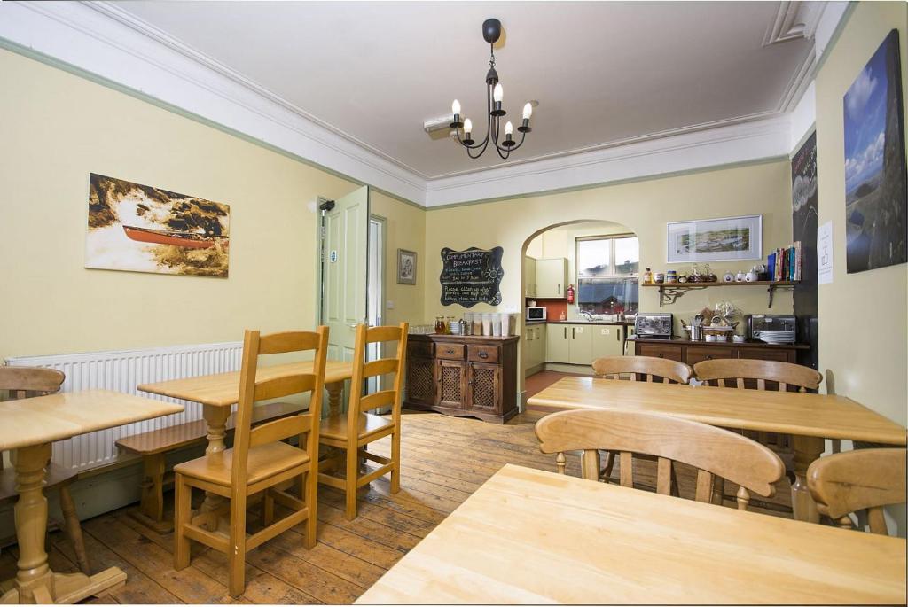 comedor con mesas y sillas de madera en Llangollen Hostel Self-catering, en Llangollen
