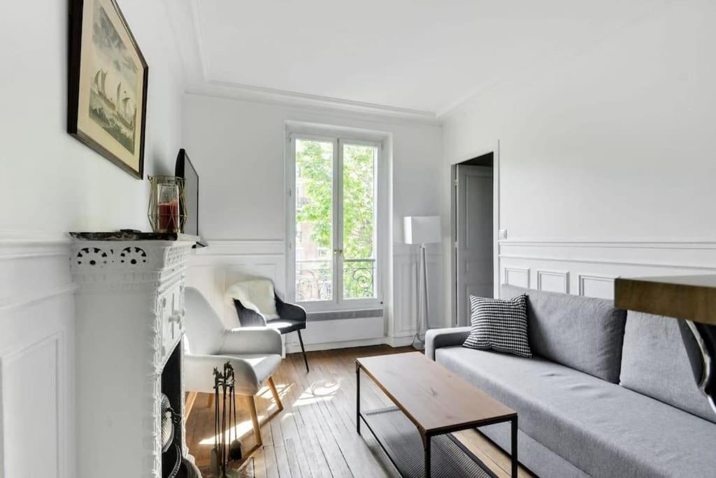 un salon avec un canapé et une cheminée dans l'établissement Charmant appartement entier à Montmartre pour 4, à Paris