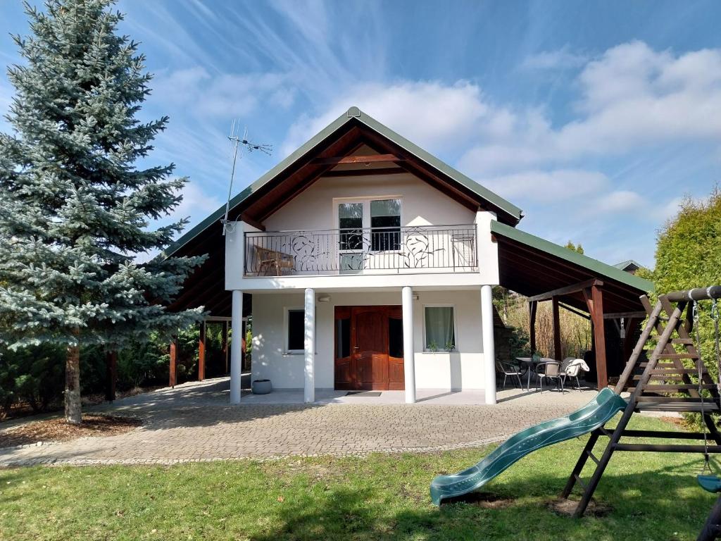 a house with a slide in front of it at Domek Chmiel II nad Jeziorem Tarnobrzeskim in Chmielów