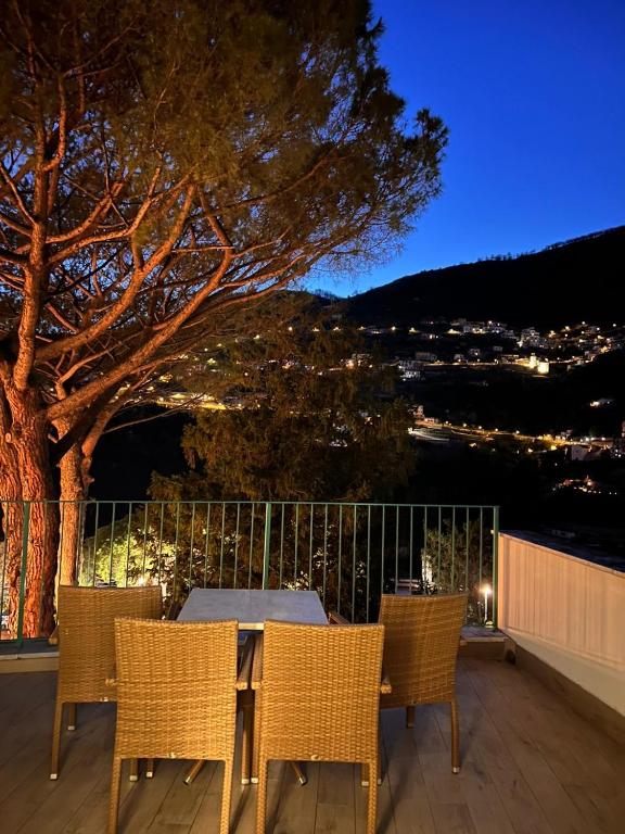 a table and chairs on a deck with a tree at Duomo Attic (rooms) in Ravello