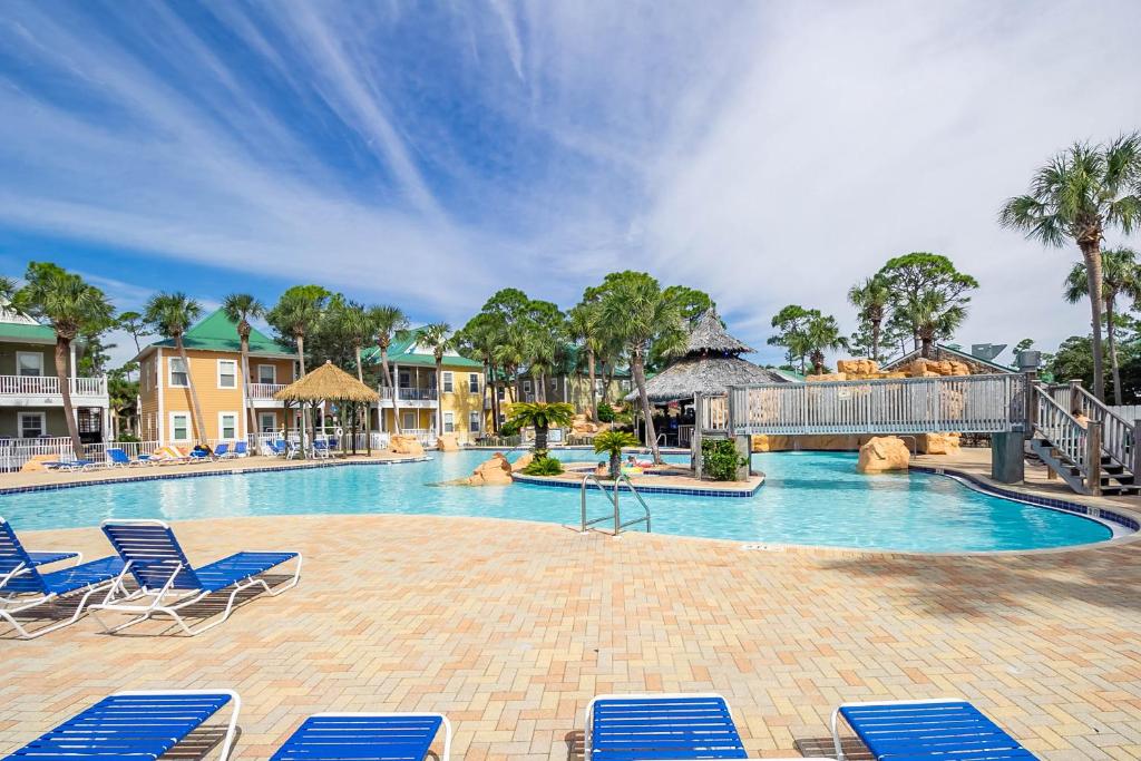 einen Pool in einem Resort mit blauen Liegestühlen in der Unterkunft Parrot Bay 37cu By Pkrm in Pensacola