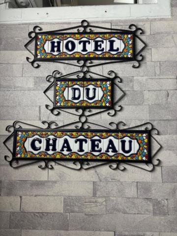two signs on the side of a brick wall at HOTEL DU CHATEAU in Paris