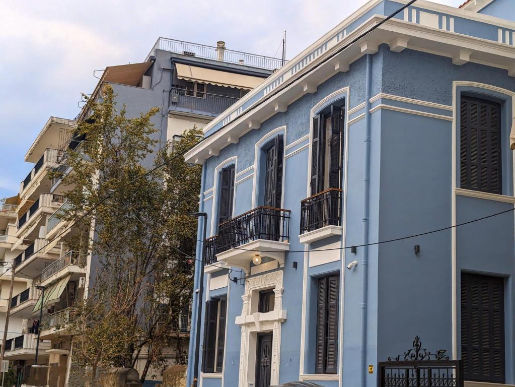 uma casa azul em frente a alguns edifícios em Villa Clio, a Luxury Collection em Tessalônica